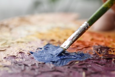 Photo of Painting with palette and paintbrush, closeup view