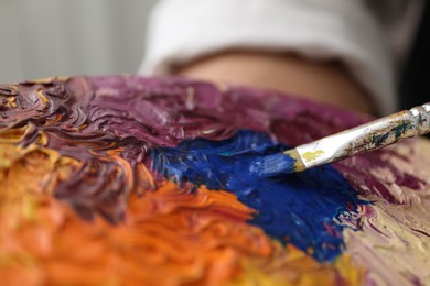 Photo of Painting with palette and paintbrush, closeup view