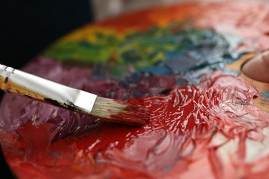 Photo of Painting with palette and paintbrush, closeup view