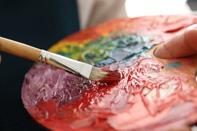 Photo of Man with palette and paintbrush, closeup view