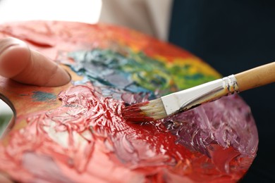 Photo of Man with palette and paintbrush, closeup view