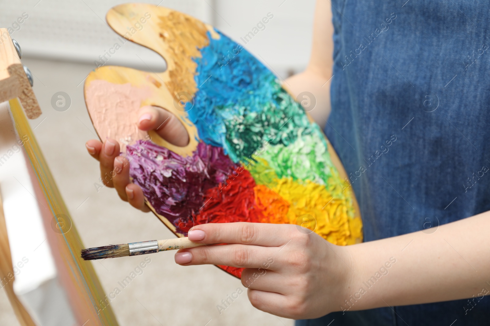 Photo of Woman with palette and paintbrush drawing picture, closeup