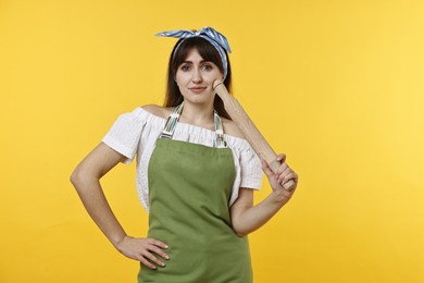 Photo of Woman with rolling pin on yellow background