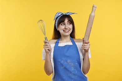 Photo of Woman with rolling pin and whisk on yellow background