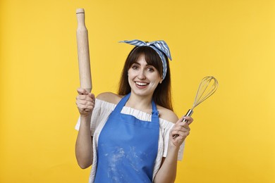 Photo of Woman with rolling pin and whisk on yellow background