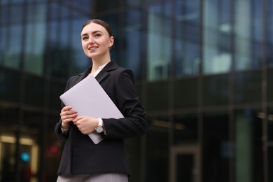 Photo of Woman in stylish formal suit with laptop outdoors. Space for text