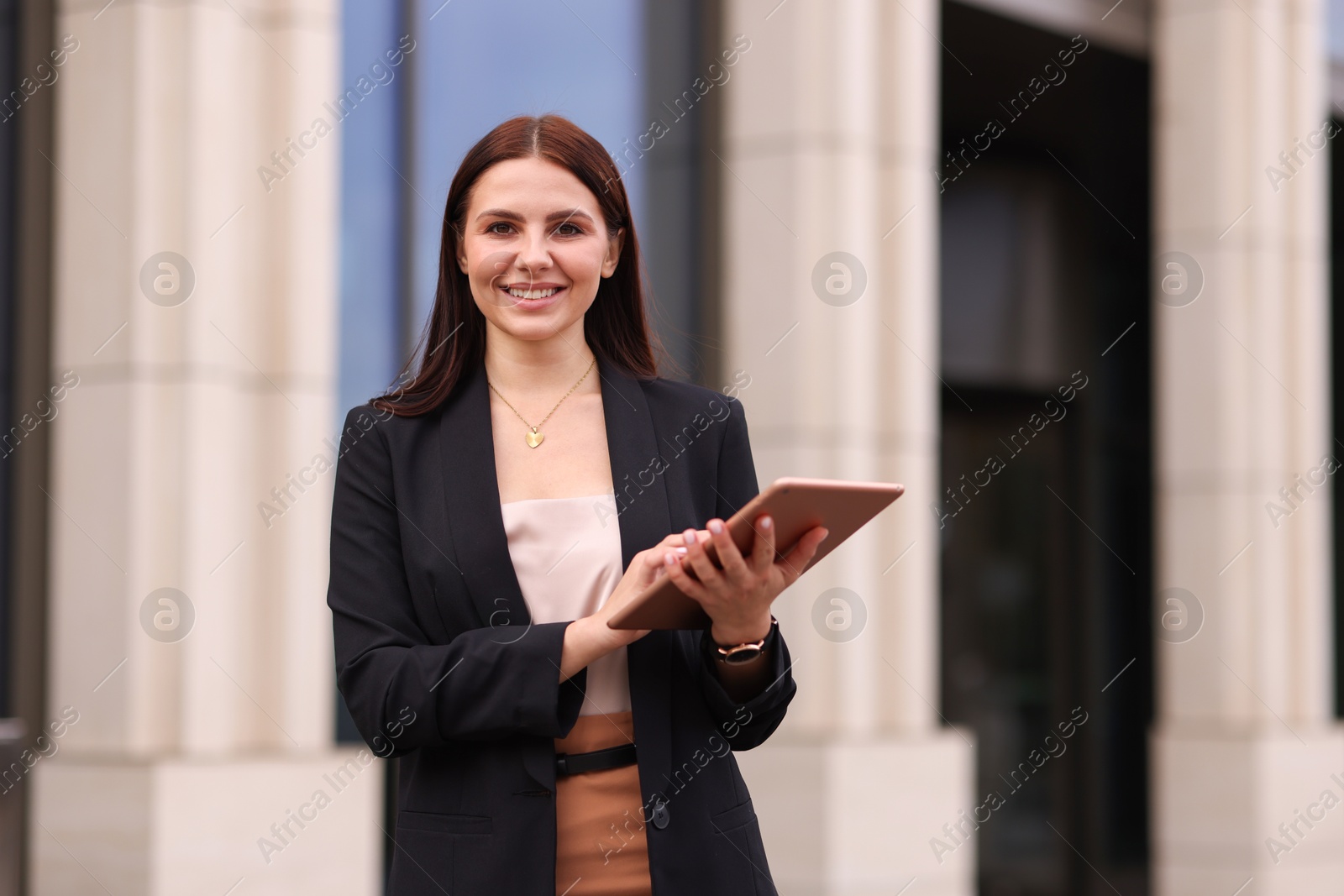 Photo of Woman in stylish formal suit with tablet outdoors