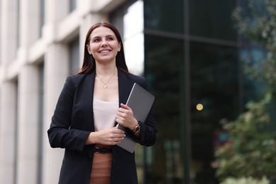 Photo of Woman in stylish formal suit with laptop outdoors. Space for text