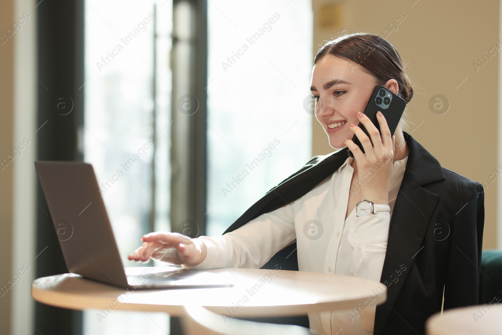 Photo of Woman in stylish formal suit working at table indoors