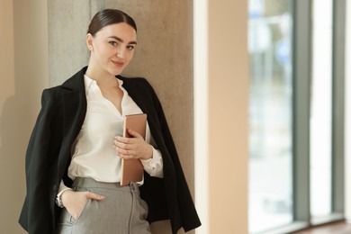 Photo of Woman in stylish formal suit with tablet indoors. Space for text