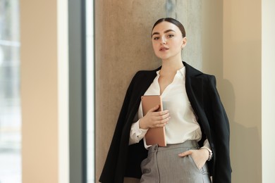 Photo of Woman in stylish formal suit with tablet indoors. Space for text