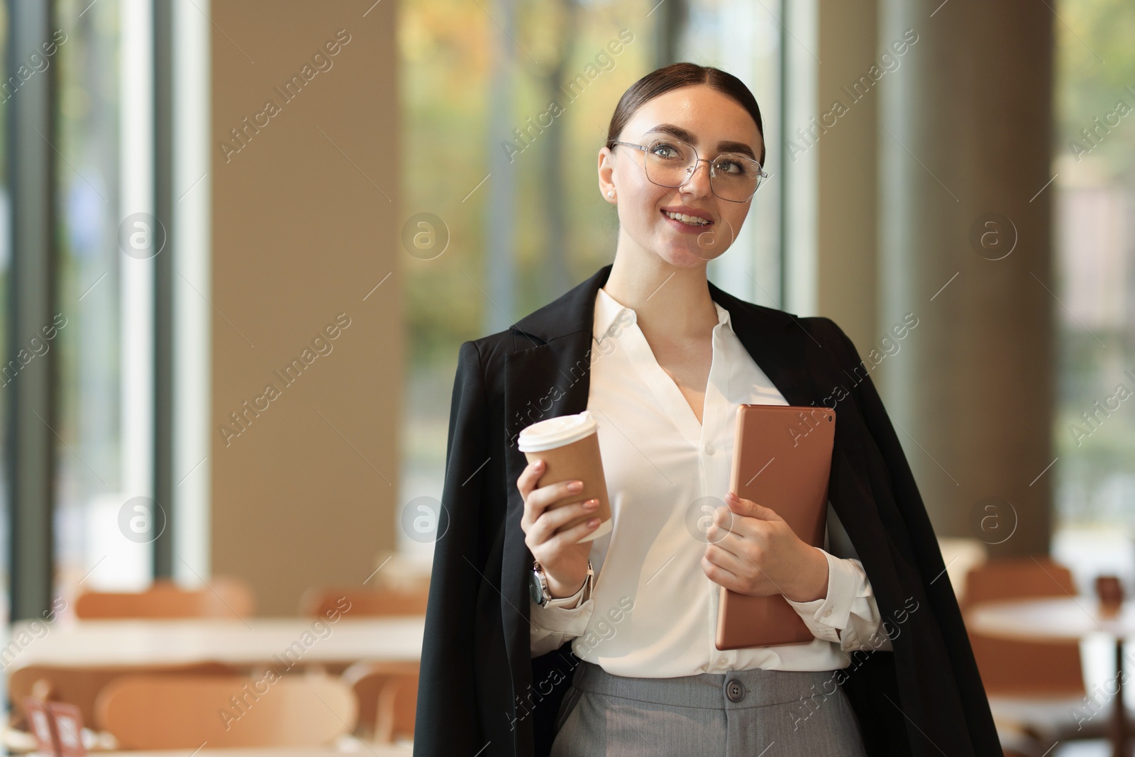 Photo of Woman in stylish formal suit with tablet and coffee indoors