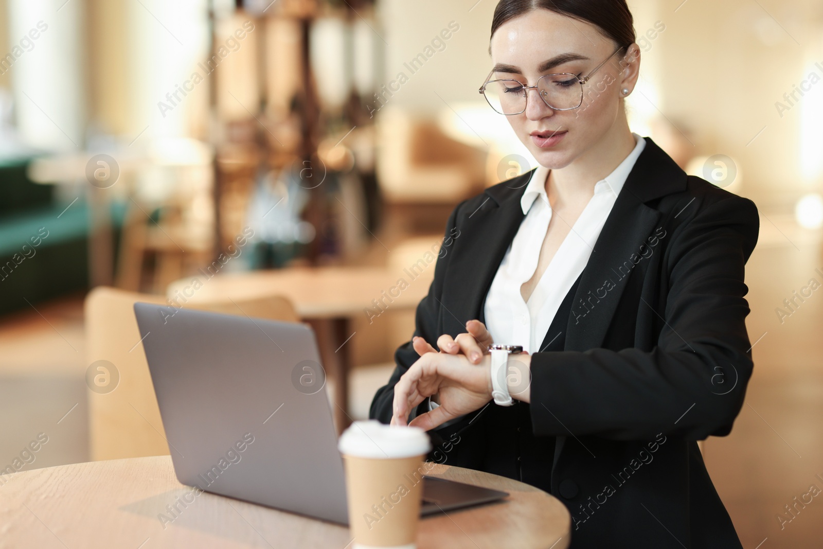 Photo of Woman in stylish formal suit working on laptop at table indoors