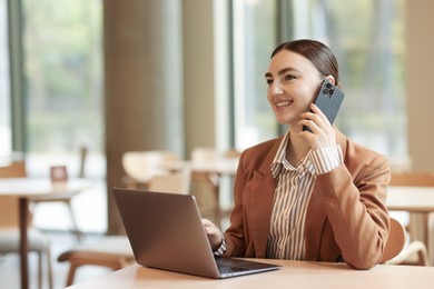 Photo of Woman in stylish formal suit working at table indoors