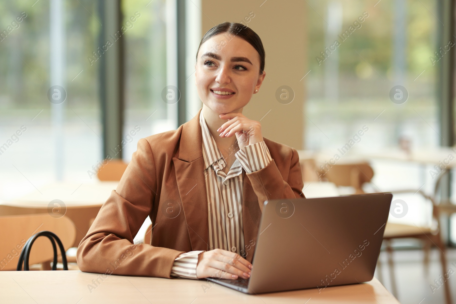 Photo of Woman in stylish formal suit with laptop at table indoors