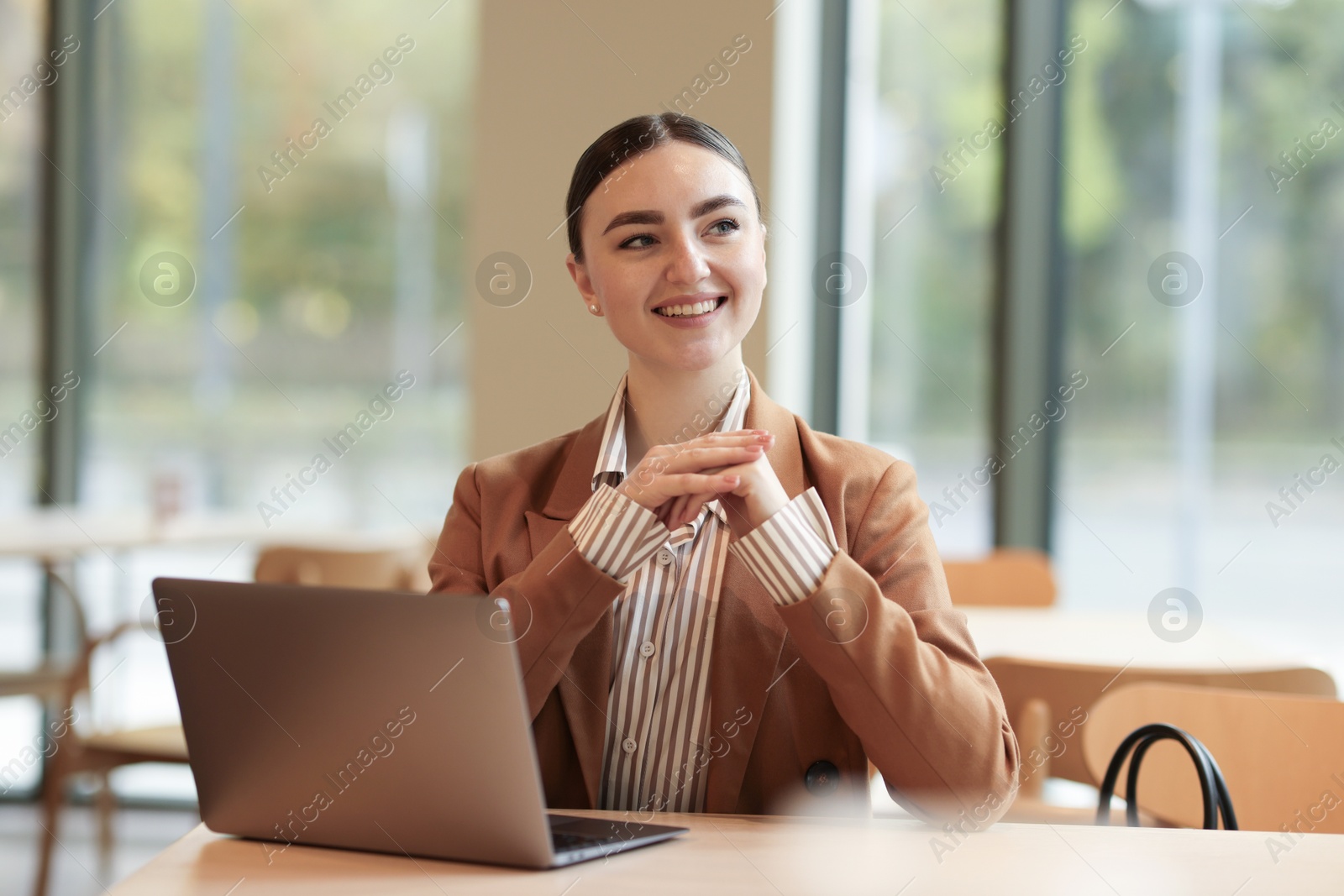 Photo of Woman in stylish formal suit with laptop at table indoors