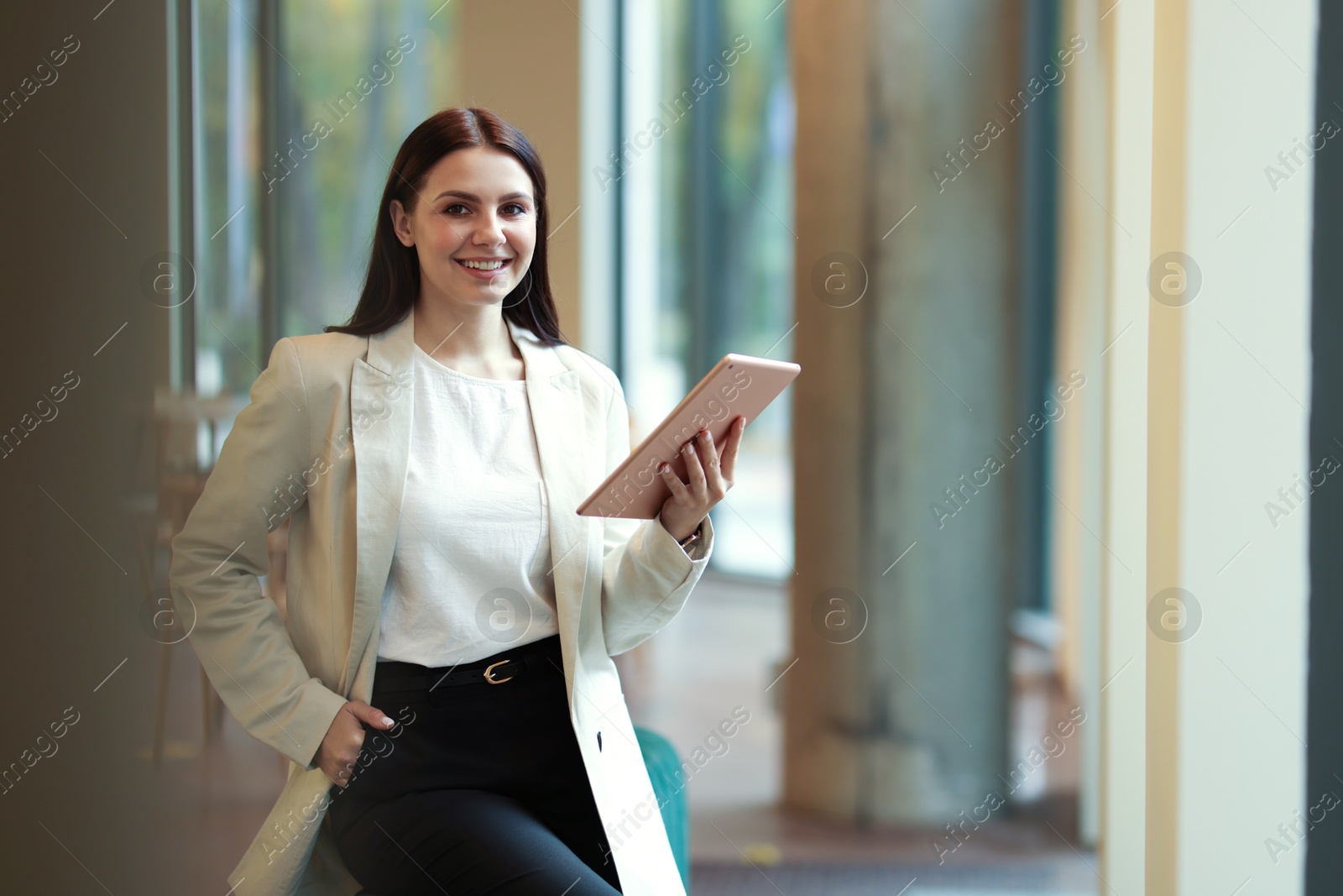 Photo of Woman in stylish formal suit with tablet indoors. Space for text