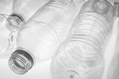 Photo of Empty plastic bottles on white background, closeup