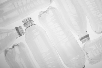 Photo of Empty plastic bottles on white background, top view