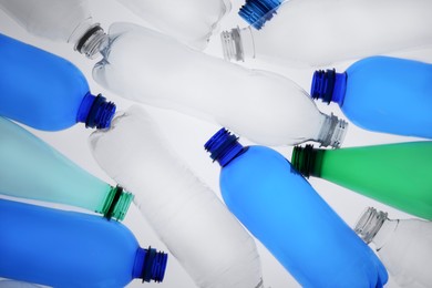 Photo of Empty plastic bottles on white background, top view