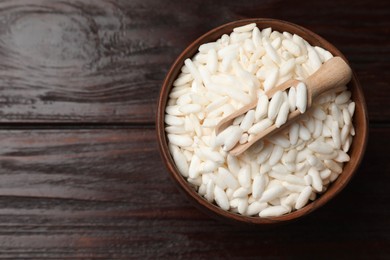 Photo of Puffed rice in bowl and scoop on wooden table, top view. Space for text