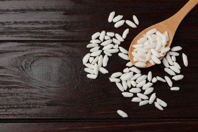 Photo of Spoon with puffed rice on wooden table, top view. Space for text