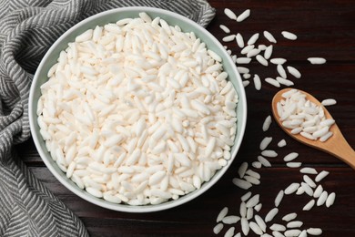 Photo of Puffed rice in bowl and spoon on wooden table, flat lay