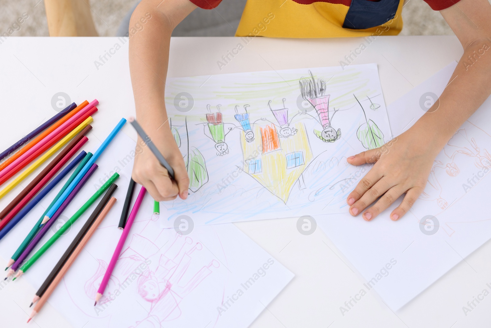 Photo of Boy drawing his family at white table indoors, above view