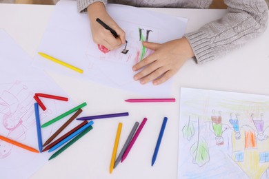 Photo of Boy drawing his family at white table, top view