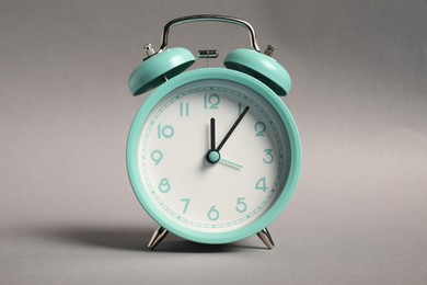 Photo of One turquoise alarm clock on grey background