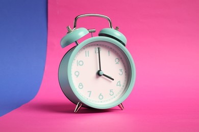 Photo of One turquoise alarm clock on color background