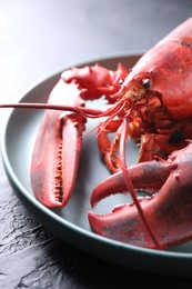 Photo of Delicious boiled lobster on black table, closeup