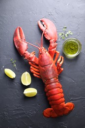 Photo of Delicious boiled lobster with lime pieces, oil and microgreens on black table, flat lay