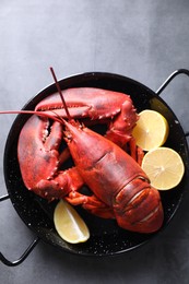 Photo of Delicious boiled lobster with lemon pieces on grey table, top view