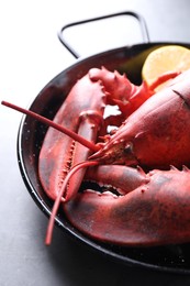 Photo of Delicious boiled lobster with lemon pieces on grey table, closeup