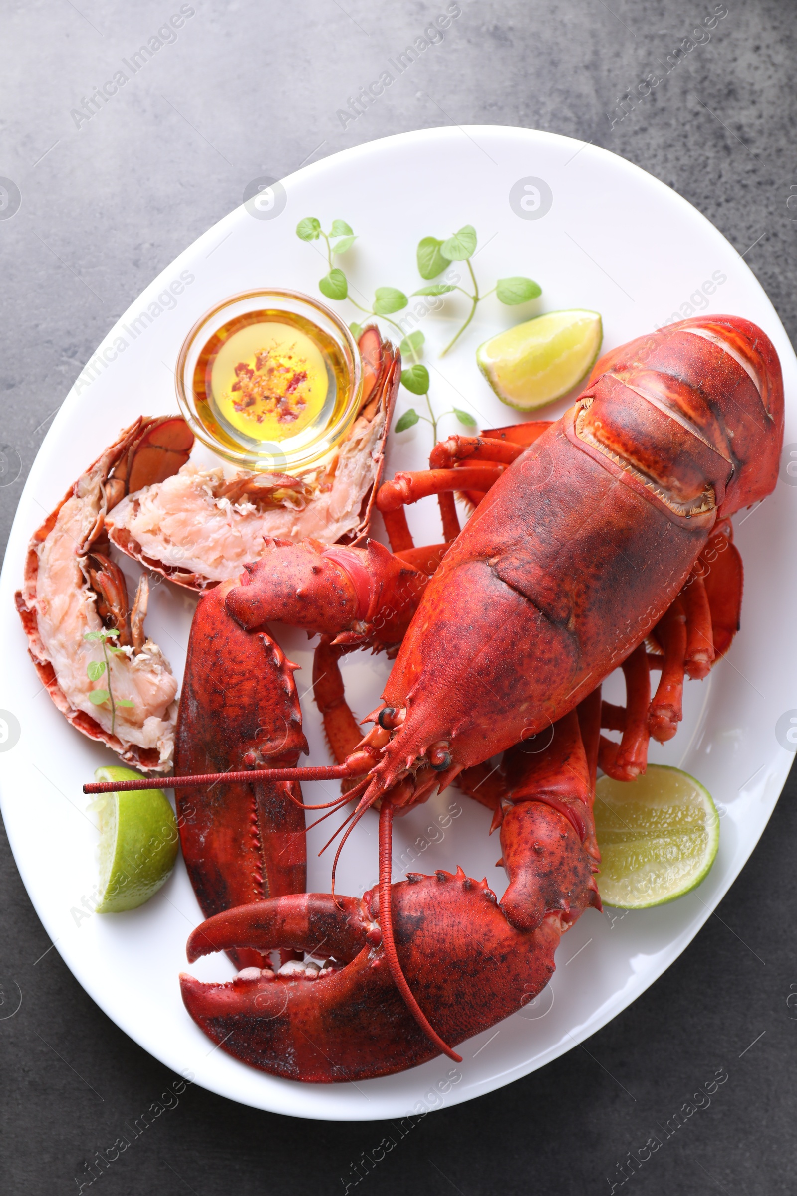 Photo of Delicious boiled lobster served on grey table, top view