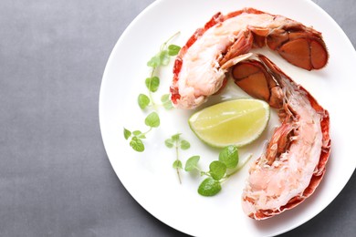 Photo of Delicious tail of boiled lobster served on grey table, top view