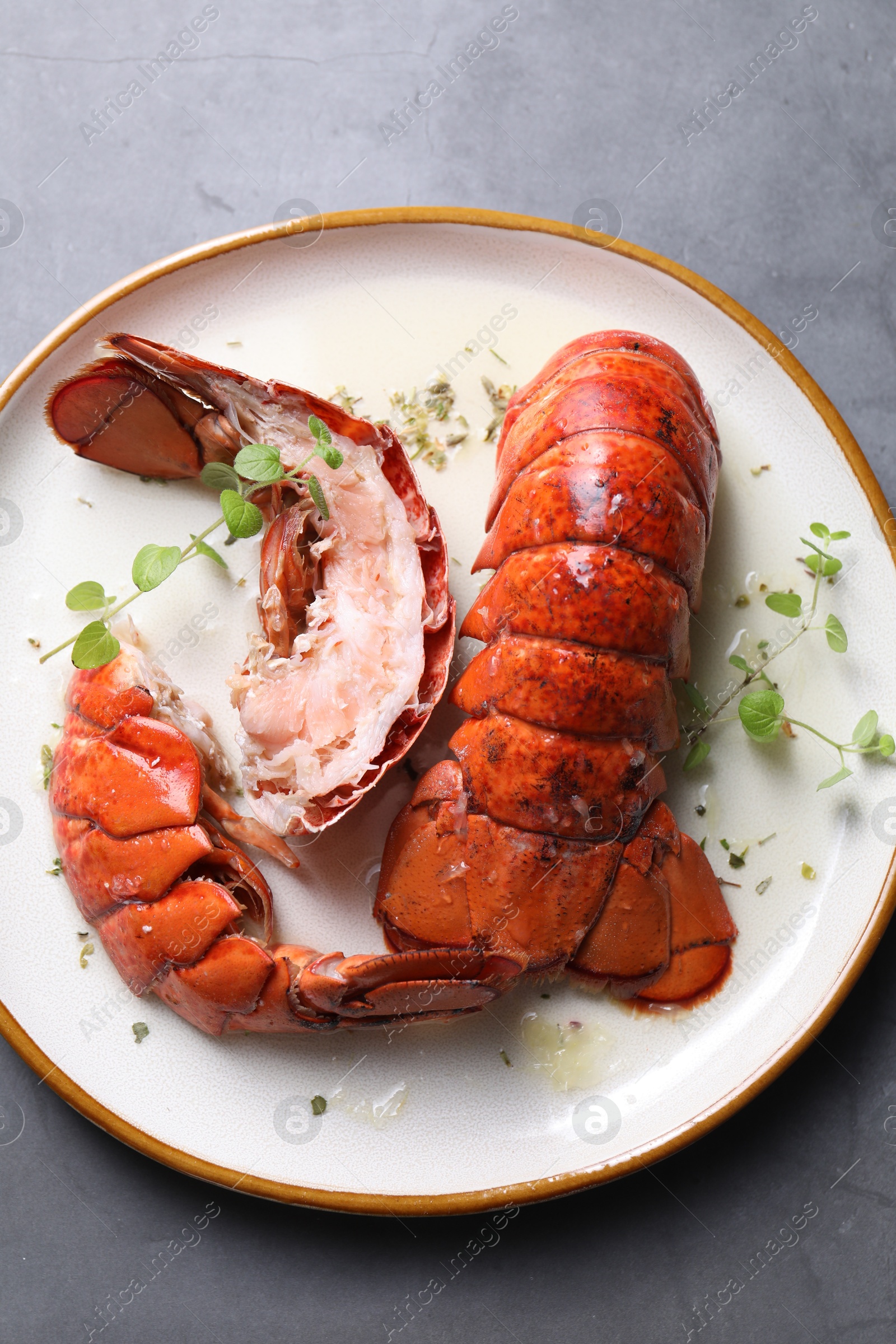 Photo of Delicious tails of boiled lobsters served on grey table, top view