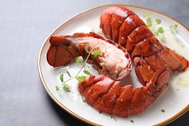 Photo of Delicious tails of boiled lobsters served on grey table, closeup