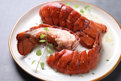 Photo of Delicious tails of boiled lobsters served on grey table, closeup