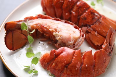 Photo of Delicious tails of boiled lobsters served on grey table, closeup