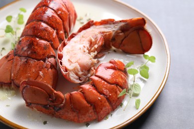 Photo of Delicious tails of boiled lobsters served on grey table, closeup