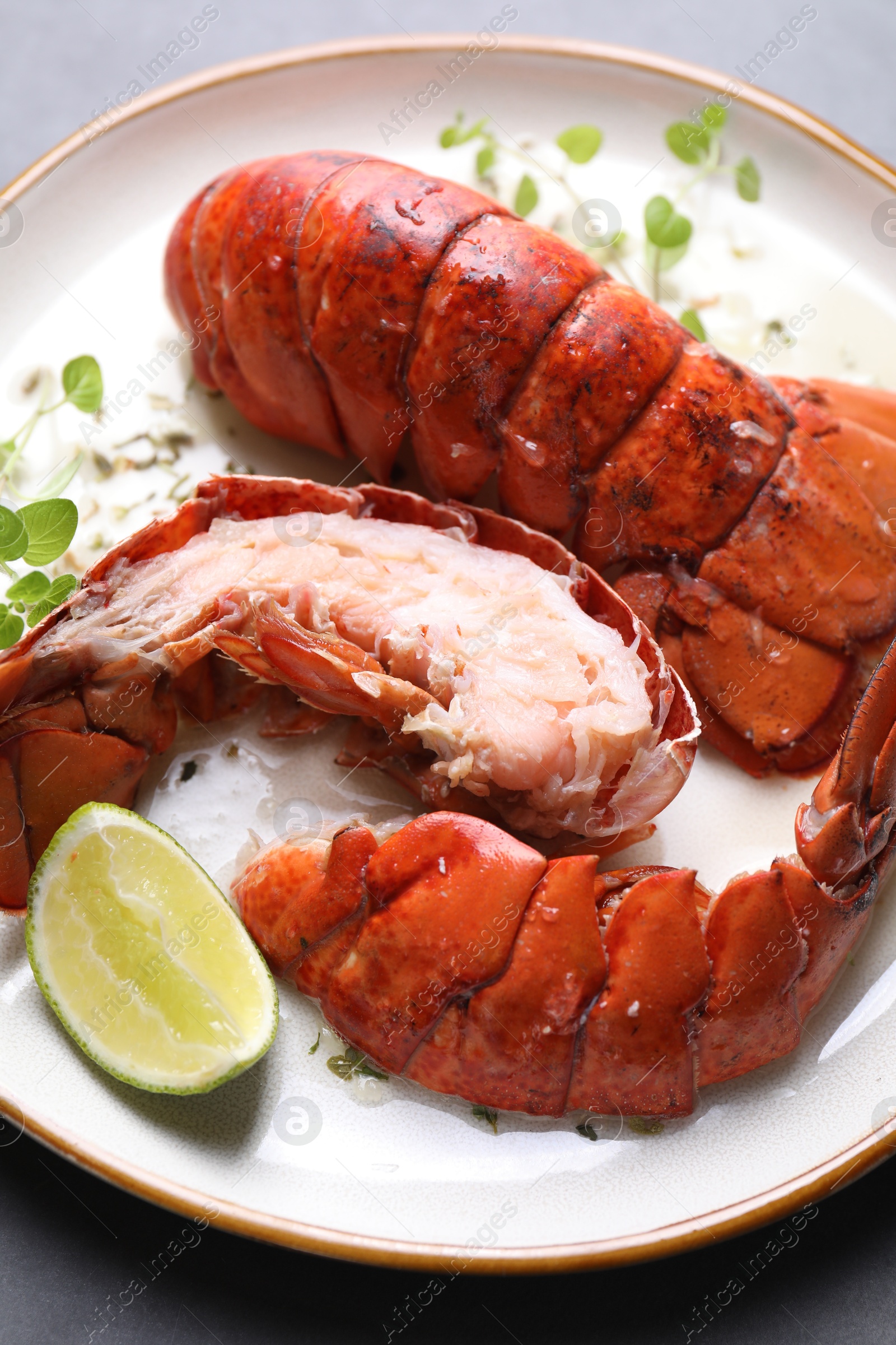 Photo of Delicious tails of boiled lobsters served on grey table, top view