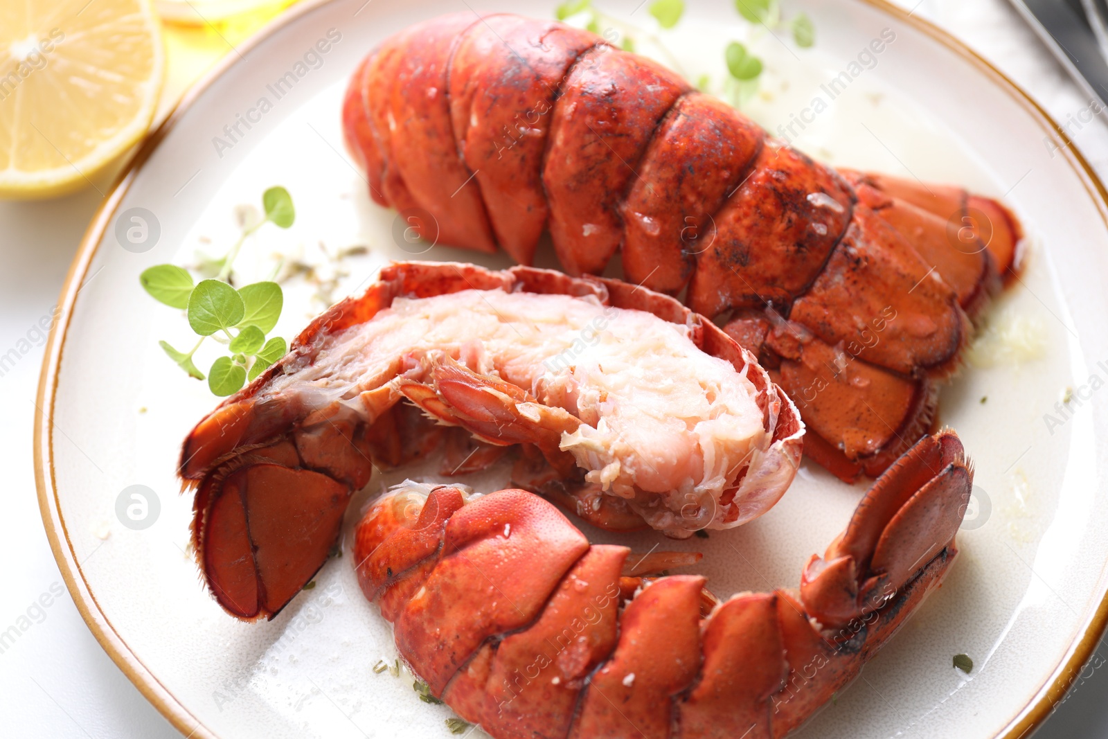 Photo of Delicious tails of boiled lobsters served on white table, closeup