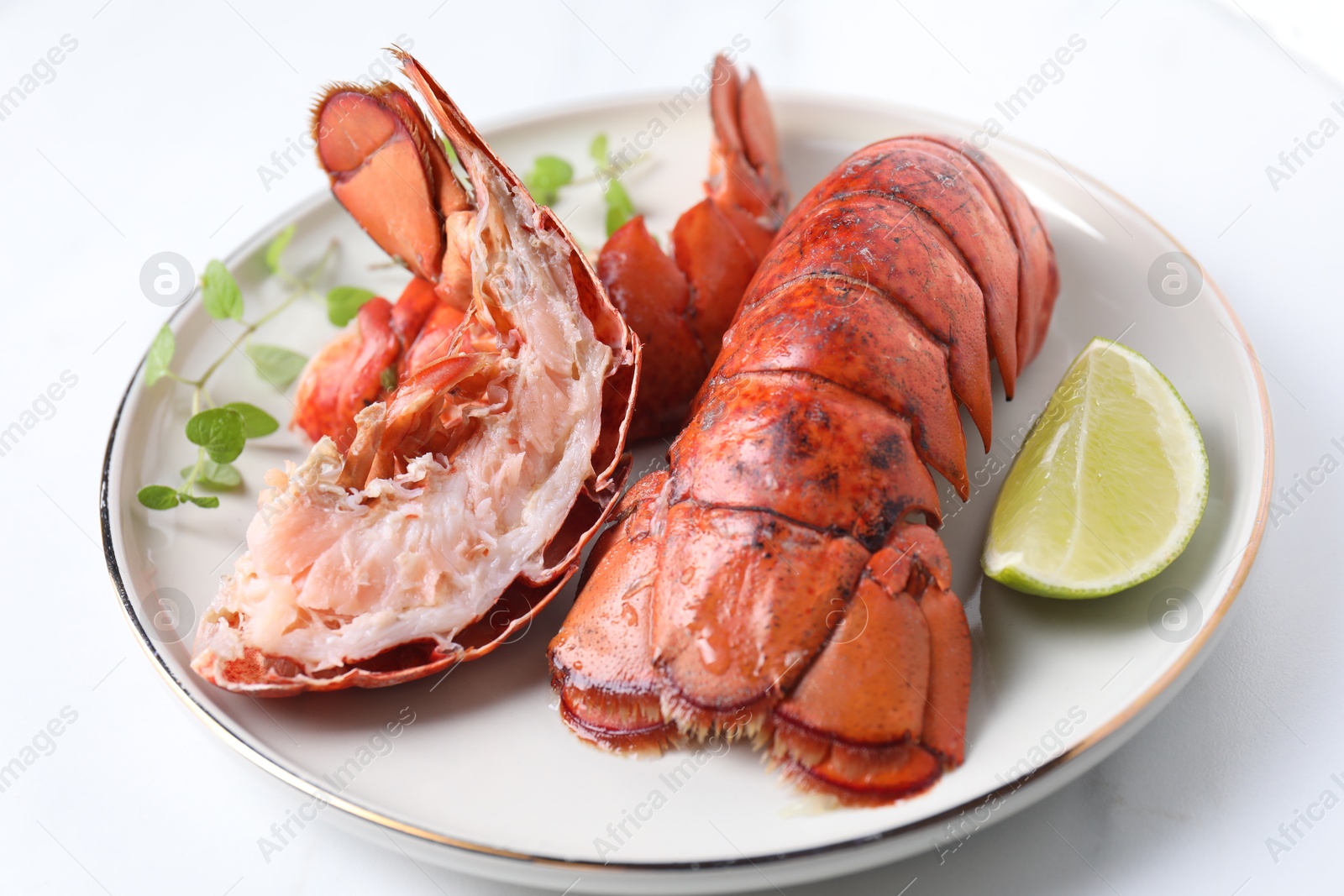 Photo of Delicious tails of boiled lobsters served on white table, closeup