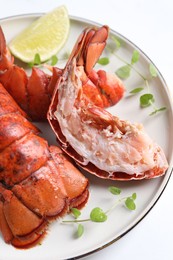 Photo of Delicious tails of boiled lobsters served on white table, closeup