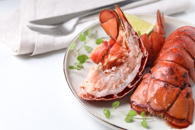 Photo of Delicious tails of boiled lobsters served on white table, closeup