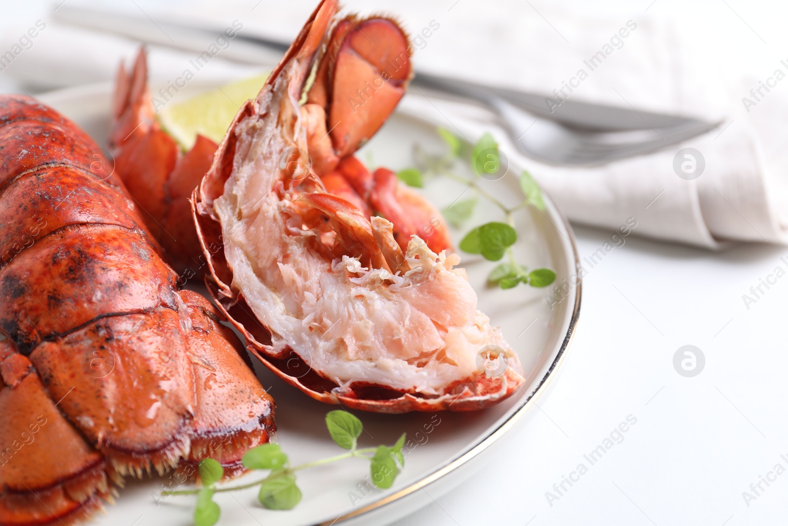 Photo of Delicious tails of boiled lobsters served on white table, closeup