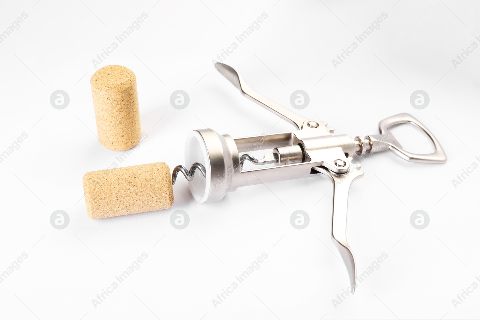 Photo of Wing corkscrew and corks on white background