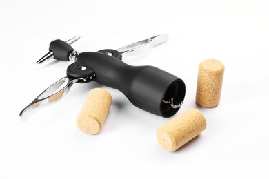 Photo of Wing corkscrew and corks on white background